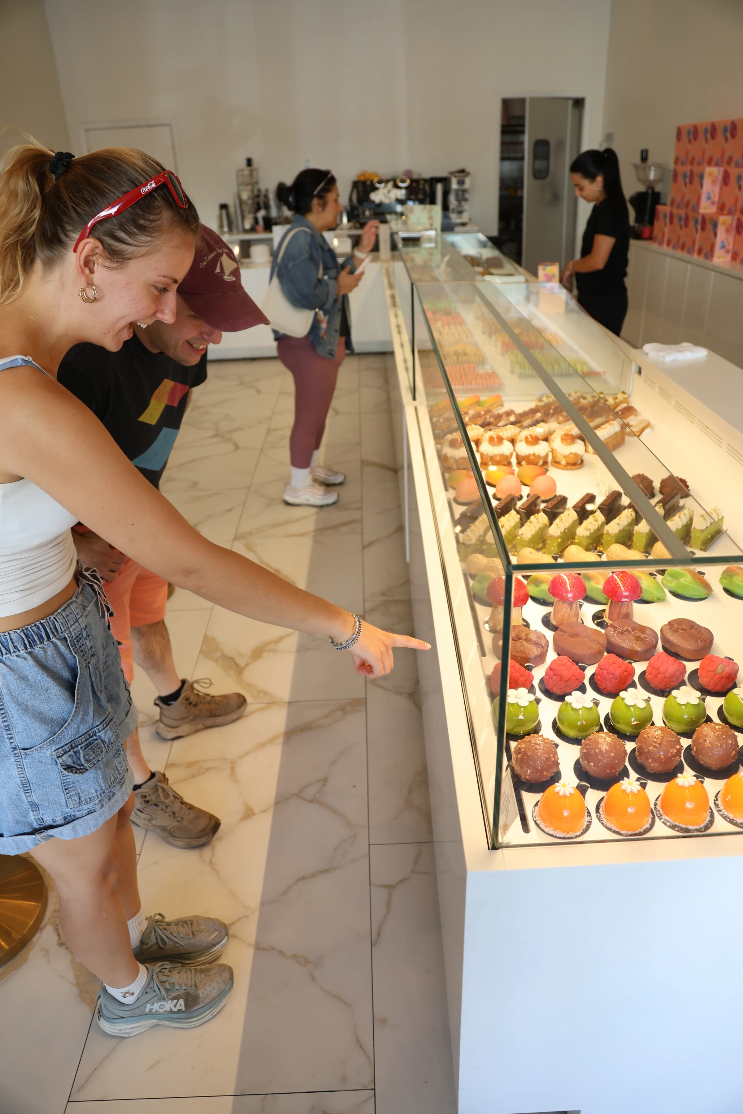 Customers browsing the pastry case at Artelice Patisserie
